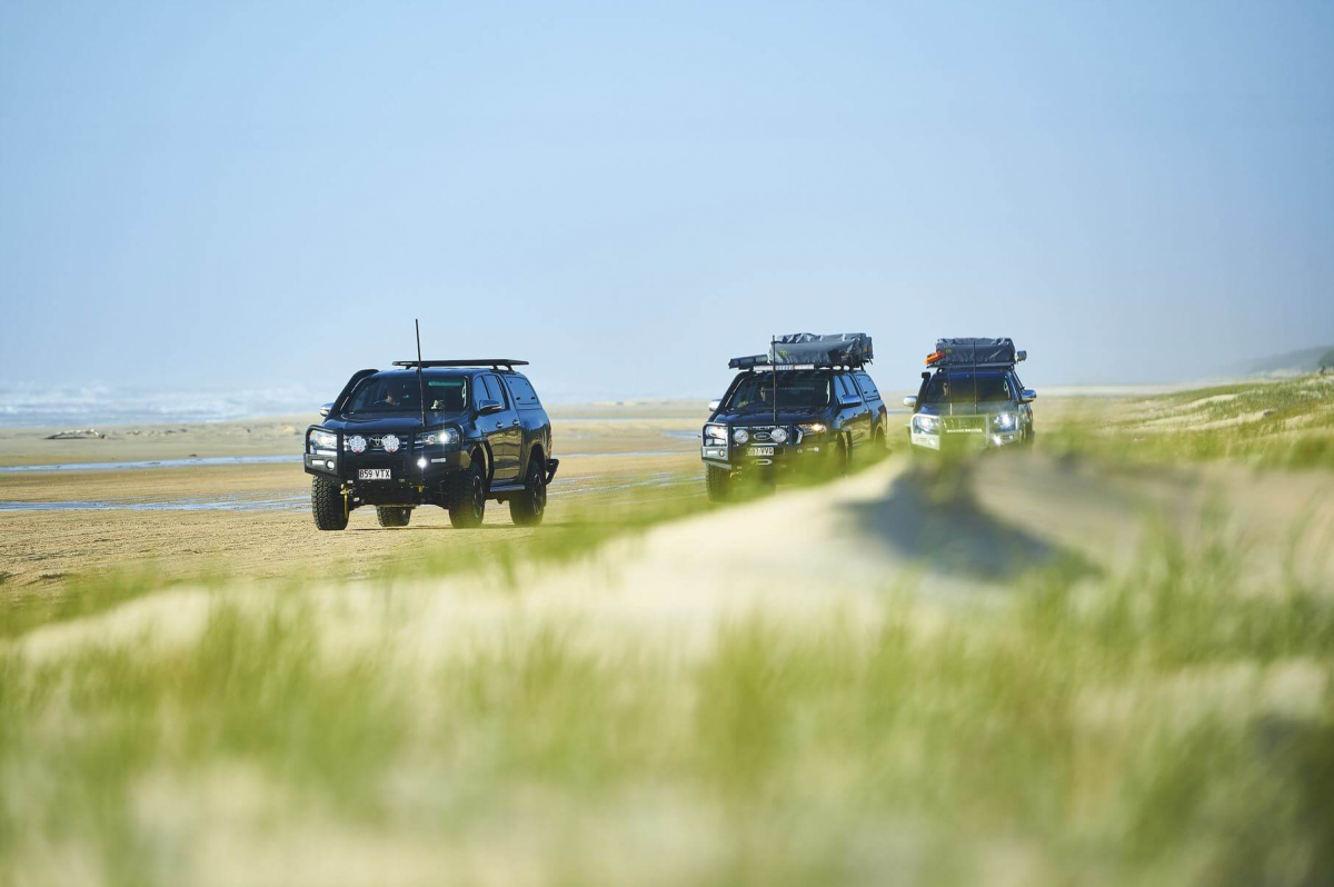 4WD vehicless in convoy on a beach